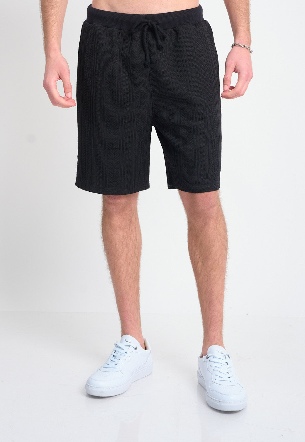 מכנסיים קצרים לגברים בצבע שחור עם קשירה במותן ועיצוב מרקם אנכי.